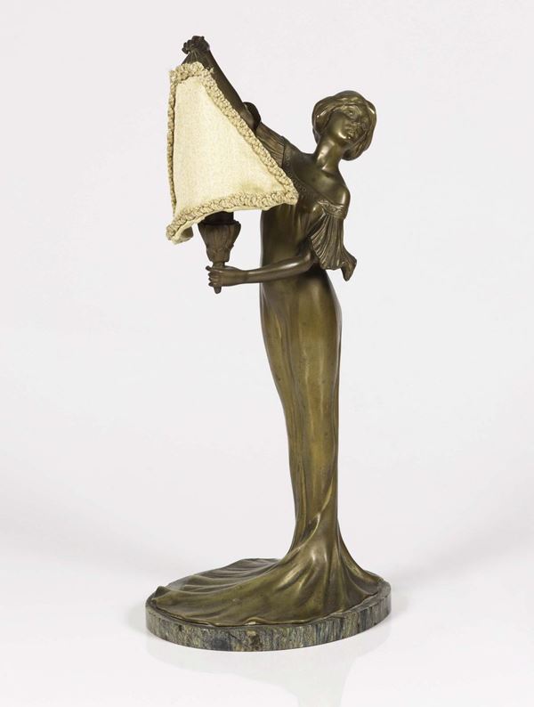 Lampada liberty in ottone dorato raffigurante donna su basamento in marmo.