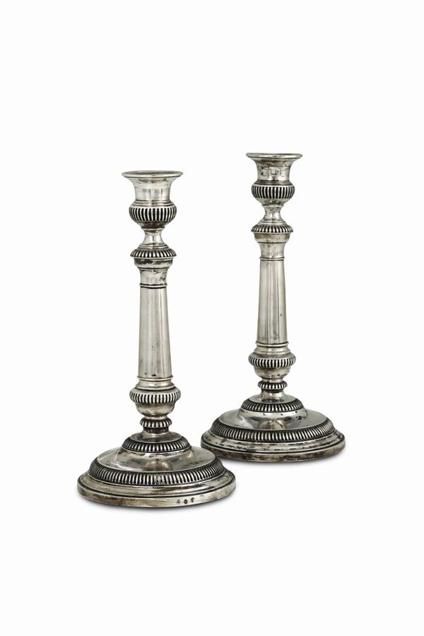 A pair of candleholders in embossed and chiselled silver, Turin, half of the 19th century, Zecca guarantee marks.