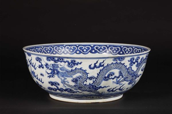 Grande bowl in porcella bianca e blu con decoro di dragoni tra le nuvole, Cina, Dinastia Qing, XIX secolo
