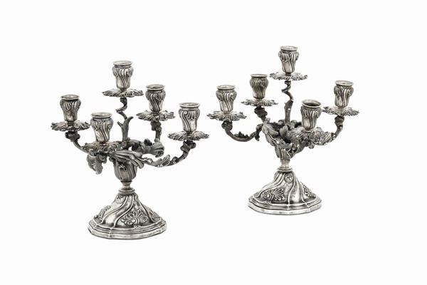 A pair of five-flame candle holders in molten, embossed and chiselled silver, Mario Buccellati, Milan second quarter of the 20th century, title stamps with fasces in use from 1935 to 1945.