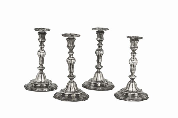 Quattro candelieri in argento fuso, sbalzato e cesellato in stile veneziano. Manifattura italiana del XIX secolo. Bollo ad imitazione del leone in molecola.