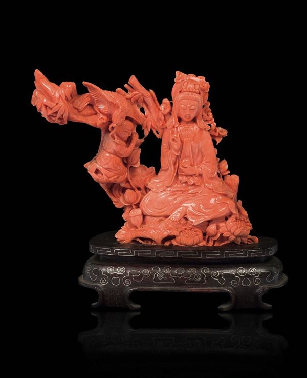 A carved coral group with Guanyin and praying child, China, early 20th century
