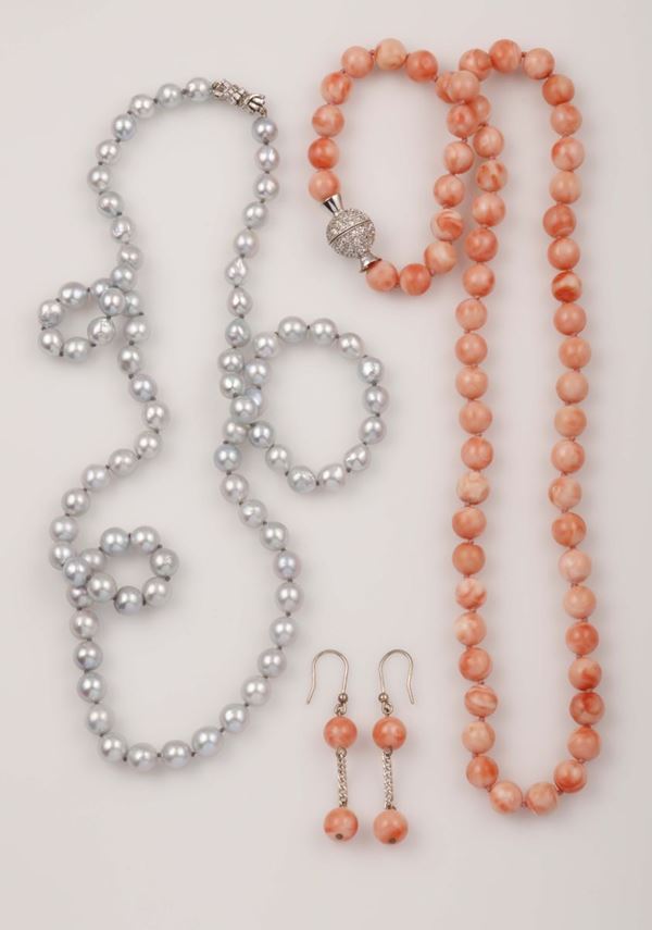 Lotto composto da una collana di perle grigie ed una parure in corallo rosa