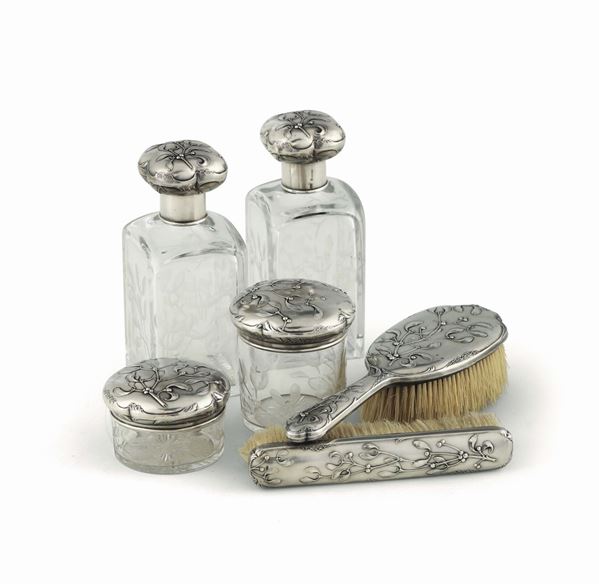 Servito da toilette composto da sei elementi in argento sbalzato e cesellato, flaconi in vetro inciso alla mola, Mosca XIX-XX secolo, bolli dell’atelier Fabergè.