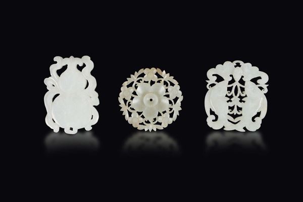 Three white jade plaques, one with two fish, one double-pumpkin and one with flowers, China, Qing Dynasty, 19th century