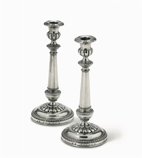 A pair of molten, embossed and chiselled silver candlesticks. Milan, early 19th century, guarantee marks in use from 1812 to 1872 (plough and globe with the zodiac and seven Tritons)
