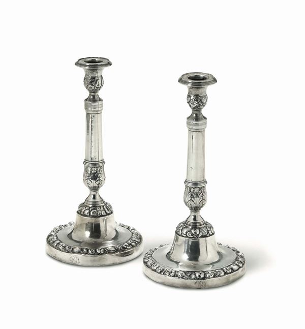 A pair of candlesticks in molten, embossed and chiselled silver. Naples, half of the 19th century, guarantee marks (in use from 1832 to 1872) and stamps for silversmith  P. Sisino and for assayer Paolo De Blasio.