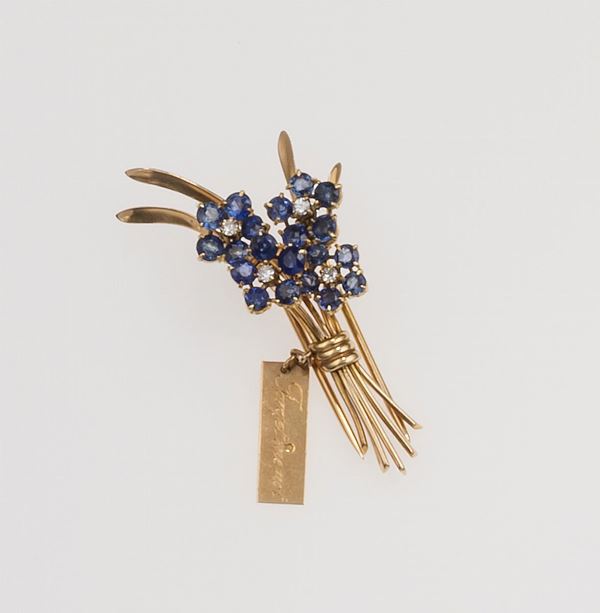 Forget-me-not sapphire and diamond brooch. The words Forget me not are engraved on one side of the tag, and Van Cleef & Arpels (Country of origin France) on the other