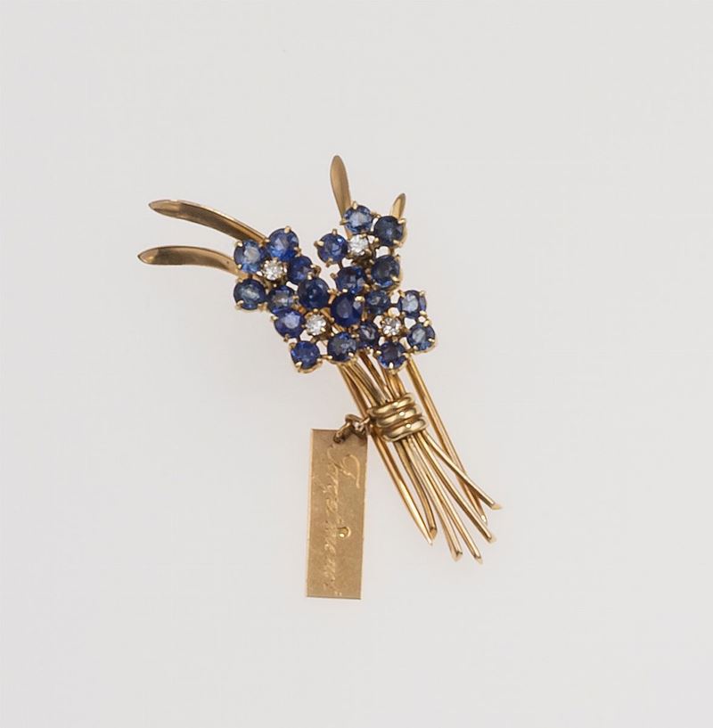 Forget-me-not sapphire and diamond brooch. The words Forget me not are engraved on one side of the tag, and Van Cleef & Arpels (Country of origin France) on the other  - Auction 100 designer jewels - Cambi Casa d'Aste