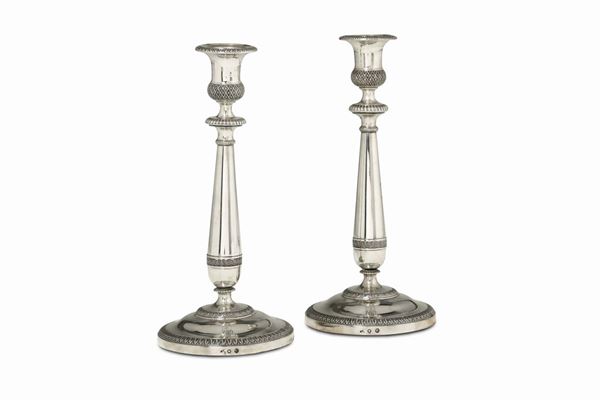 A pair of candle holders in molten, embossed and chiselled silver, Mantua (?), half of the 19th century, guarantee and control marks.