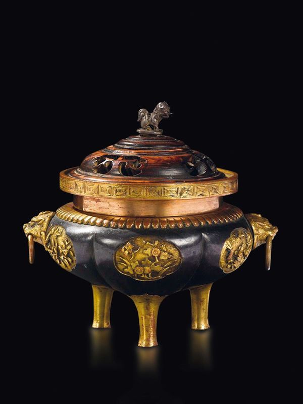 A burnished and gilt bronze tripod censer with fretworked wooden cover, China, Qing Dynasty, Qianlong Period (1736-1795)