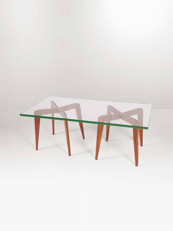 Tavolo basso con supporti in legno lucido e piano in vetro molato.