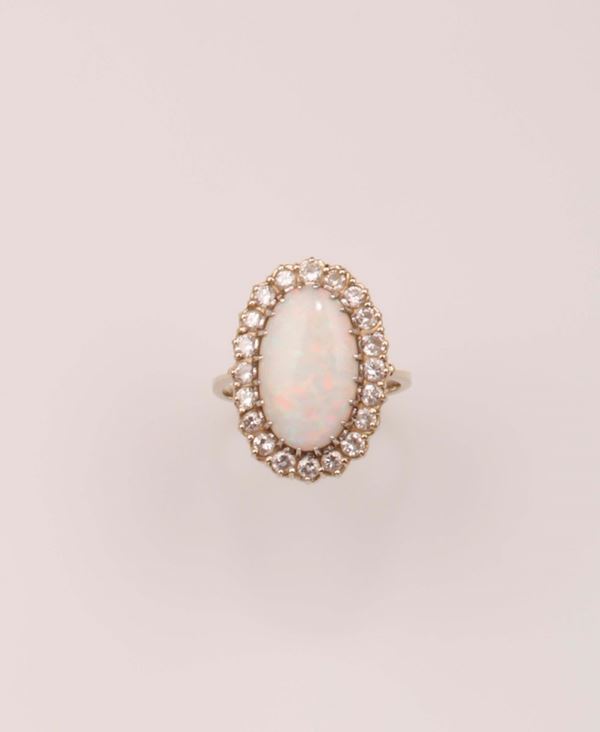 Anello con opale taglio ovale e diamanti a contorno