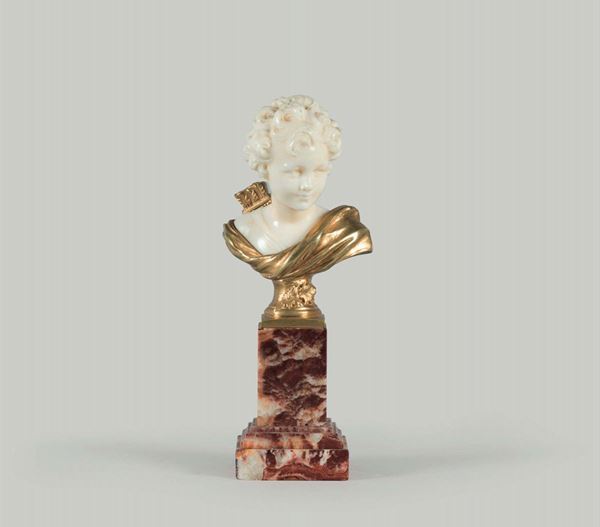 Francia, 1900 ca. A small bust of a boy in ivory and gilded bronze on a marble stand