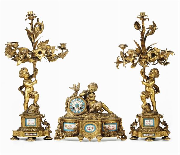 Trittico da camino composto da orologio e due candelabri in bronzo dorato, Francia XIX secolo