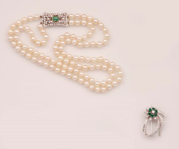 Lotto composto da un girocollo con perle coltivate ed una spilla con diamanti e smeraldi