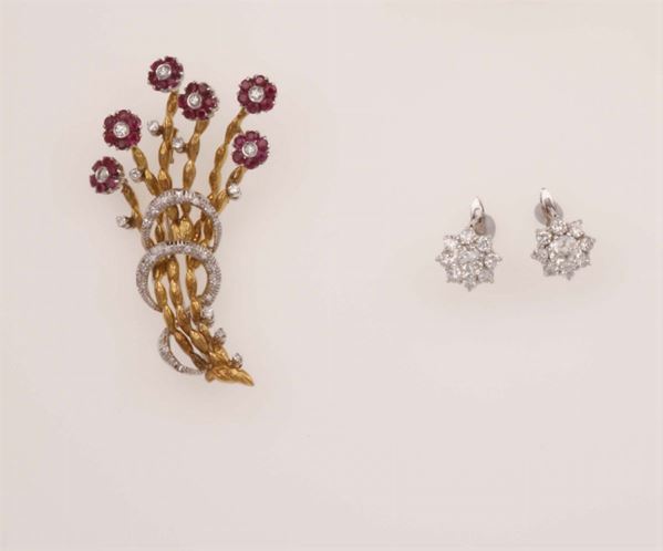 Lotto composto da un paio di orecchini con diamanti ed una spilla a soggetto floreale con diamanti e rubini