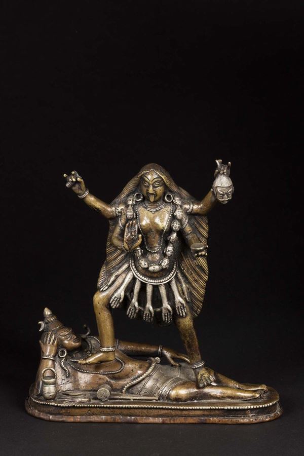 A bronze sculpture with silver inserts depicting a dancing deity, India, 19th century