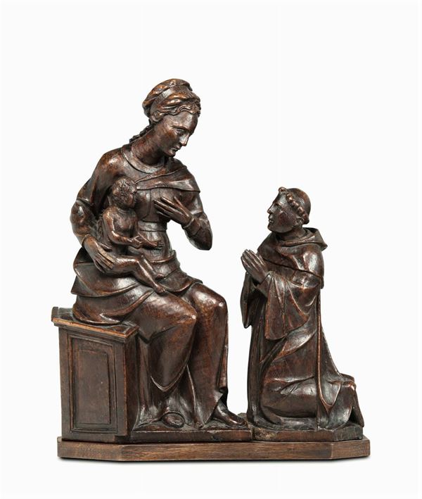 A wooden group depicting a Madonna with Child and praying friar. Sculptor from Piedmont or France, 16th century