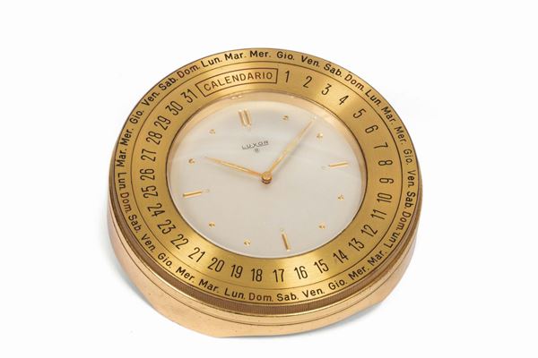 Luxor. Fine, gilt brass table clock with calendar and 8 days power reserve. Made circa 1960