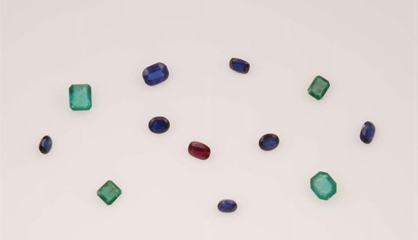 Variously shaped unmounted gemstones including rubies, emeralds and sapphires