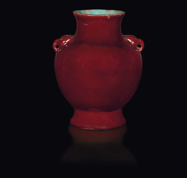 An oxblood-glazed porcelain vase with light blue insides and elephant head details, China, Qing Dynasty, 19th century