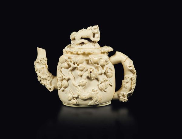 A carved ivory teapot with a peach decor and a monkey lid, China, early 20th century