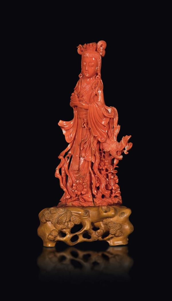 A carved coral group depicting a Guanyin with phoenix and flowers, China, early 20th century