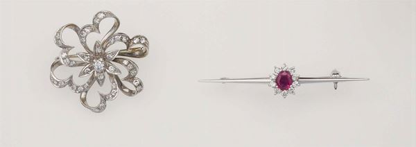 Lotto composto da una spilla a soggetto floreale con diamanti ed una spilla barretta con rubino centrale e diamanti a contorno