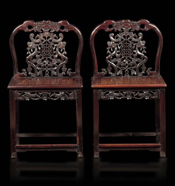 A pair of homu wood chairs with botanical motifs and symbols, China, Qing Dynasty, 19th century