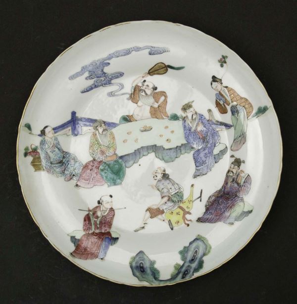 A porcelain plate with polychrome enamels depicting dignitaries within a landscape, China, Qing Dynasty, 19th century