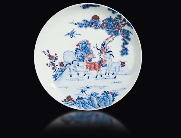 Piatto in porcellana bianca, blu e dettagli rosso ferro raffigurante capre al pascolo, Cina, Dinastia Qing, fine XIX