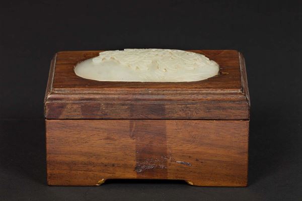 A wooden chest with a lid and a carved white jade medallion, China, Qing Dynasty, 19th century