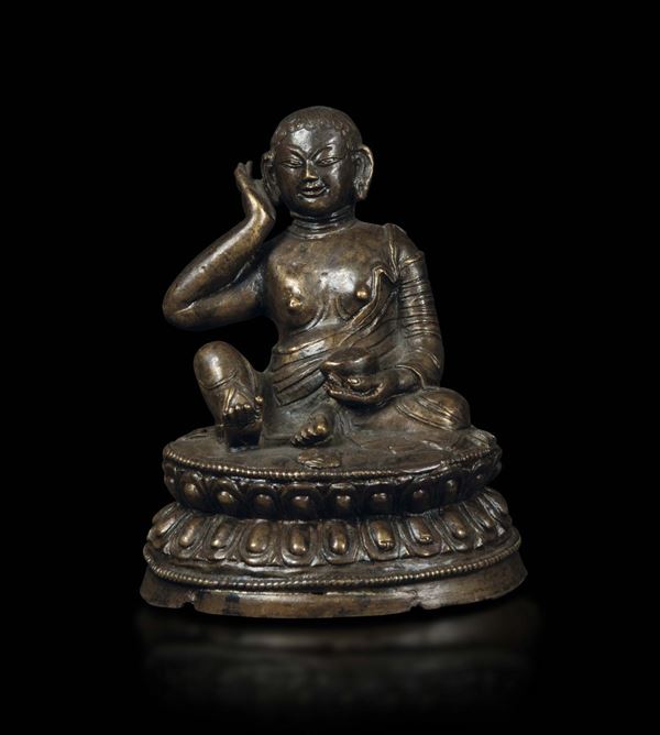 A bronze figure of Milarepa seated on a double lotus flower, Tibet, 16th-17th century
