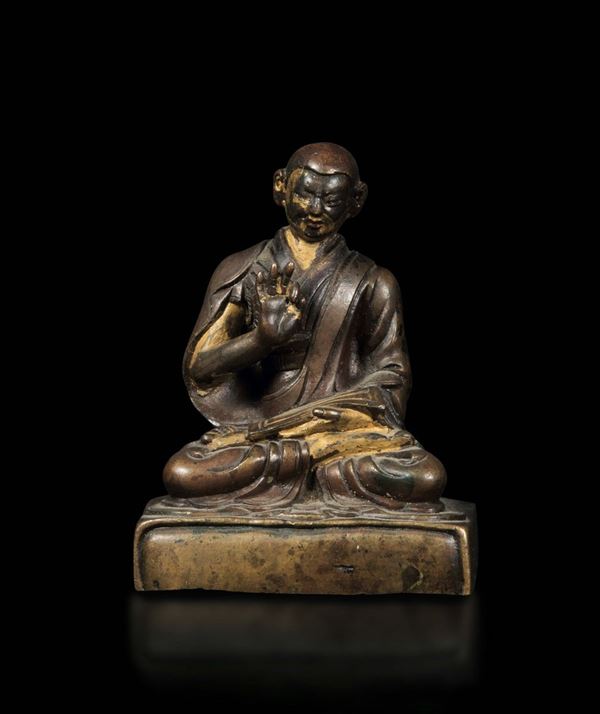 Figura di monaco seduto in bronzo con tracce di doratura a freddo, Tibet, XVI secolo