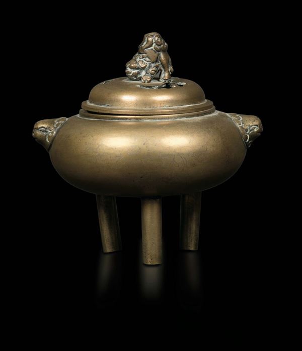 A tripodal gilt bronze censer with mascaron handles and a Pho dog on the lid, China, Qing Dynasty, 19th century