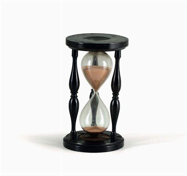 An hourglass in turned and ebonized wood and blown glass. Italy, 19th century