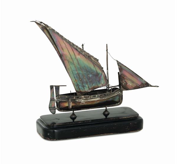 A model of a Maltese skiff in molten and chiselled silver. 20th century