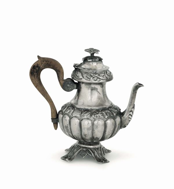 A coffee pot in molten, embossed and chiselled silver with a wooden handle. Naples, early 19th century