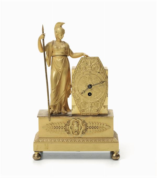 Piccola pendola da tavolo in metallo dorato. Francia, stile Impero, XIX secolo