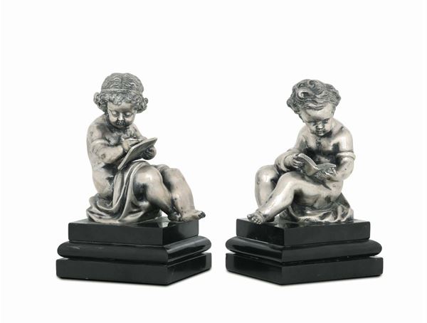 A pair of putti in molten and chiselled silver, marble stands. Artistic Italian silver work from the 19th century