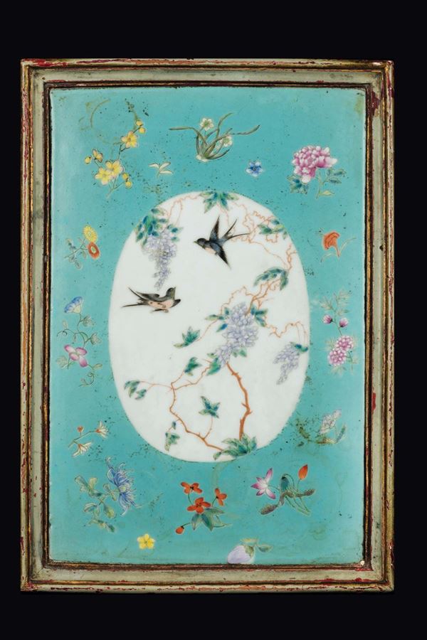 A lacquered table with golden decorations and a floral motif with a porcelain plaque depicting swallows, China, Qing Dynasty, early 20th century