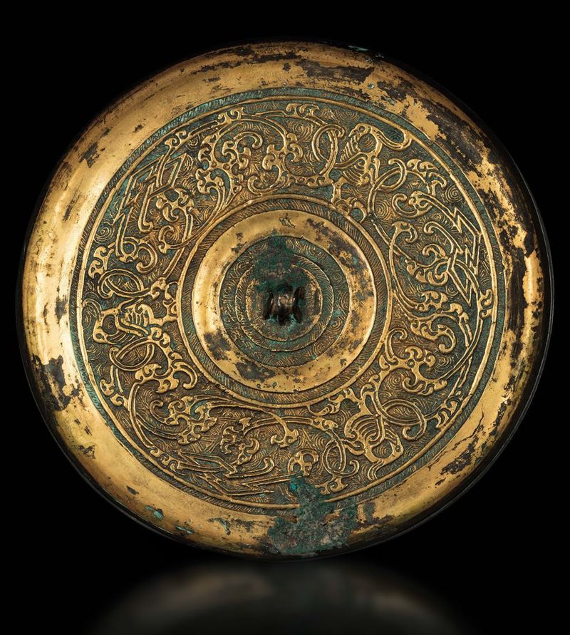 Specchio in bronzo dorato con decori a rilievo, Cina, Dinastia Han (206 a.C.-220 d.C.)  - Asta The Art of Himalayan and Chinese Bronze - II - Cambi Casa d'Aste