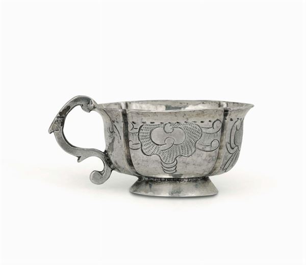 Piccola coppa con manico sagomato in argento sbalzato e cesellato di forma polilobata. Mosca 1764