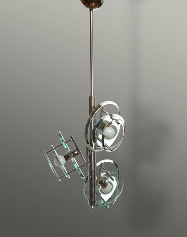 Lampada a sospensione con struttura in metallo ed elementi diffusori in vetro molato.