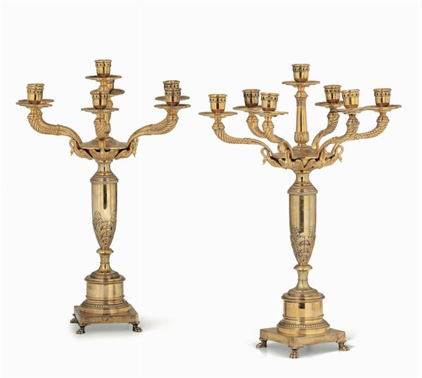 Coppia di candelabri a sette fiamme in argento fuso, sbalzato, cesellato e dorato. Manifattura artistica italiana della metà del XX secolo