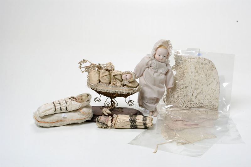 Due antichi bambinelli, uno in cera l’altro in terracotta e gruppo composto da un piccolo bambolotto vestito e da 4 cuffiette da neonato fatte all’uncinetto  - Asta Asta a Tempo Oggetti d'Arte - IV - Cambi Casa d'Aste