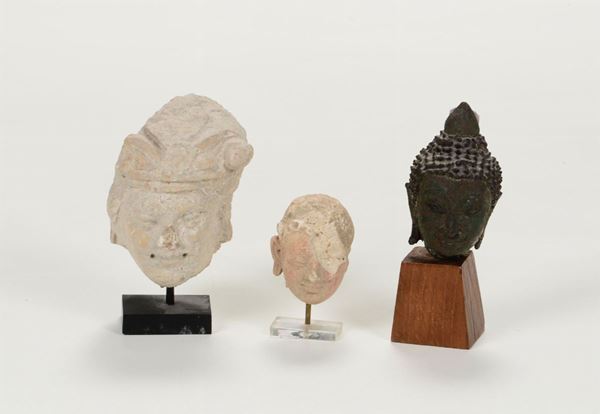Lotto composto da 3 statuette, due in stucco di epoca Gandara, l’altra in bronzo (antica) raffigurante testa di Budda (Siam)