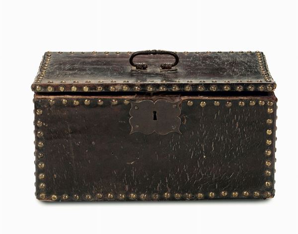 Un antico bauletto in cuoio con borchie in ottone e maniglia in ferro dorato