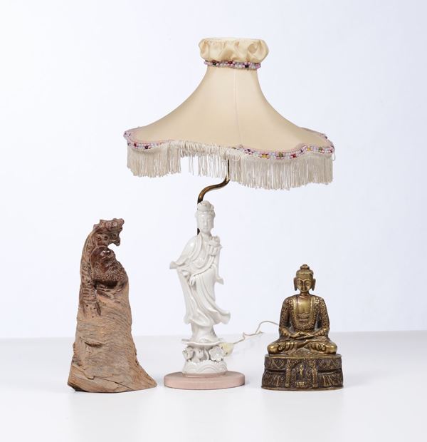 Lotto composto da un Buddha in bronzo, una scultura cinese in radica raffigurante “Saggio”, una lampada con una Guanjin in porcellana